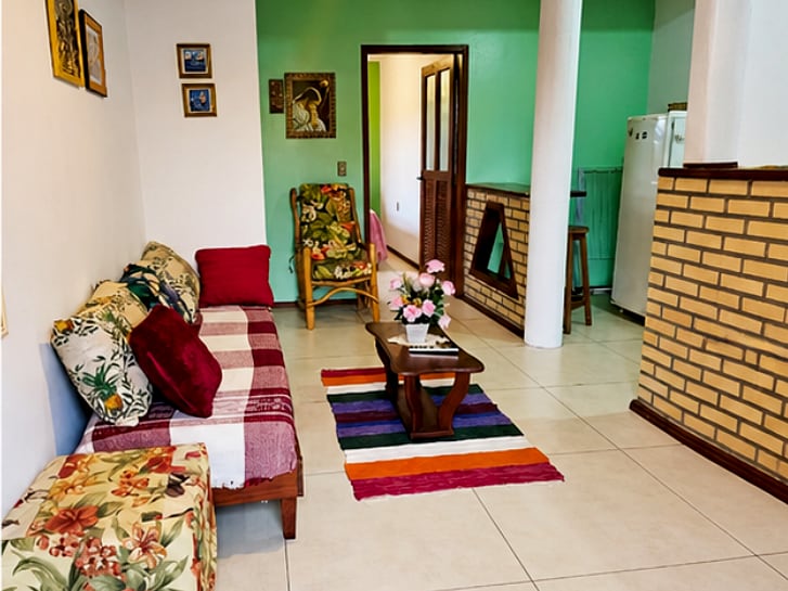 Sala do apartamento Duplo da Pousada Capricórnio, com sofá e mesa de centro