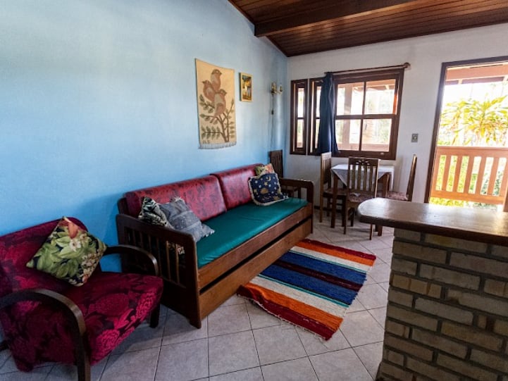 Sala de estar do Loft da Pousada Capricórnio, com sofá e acesso à varanda