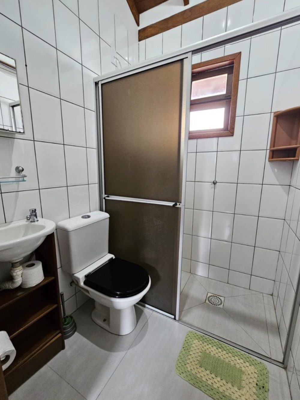 Sala de estar do apartamento Quádruplo da Pousada Capricórnio, com sofá e acesso ao quarto