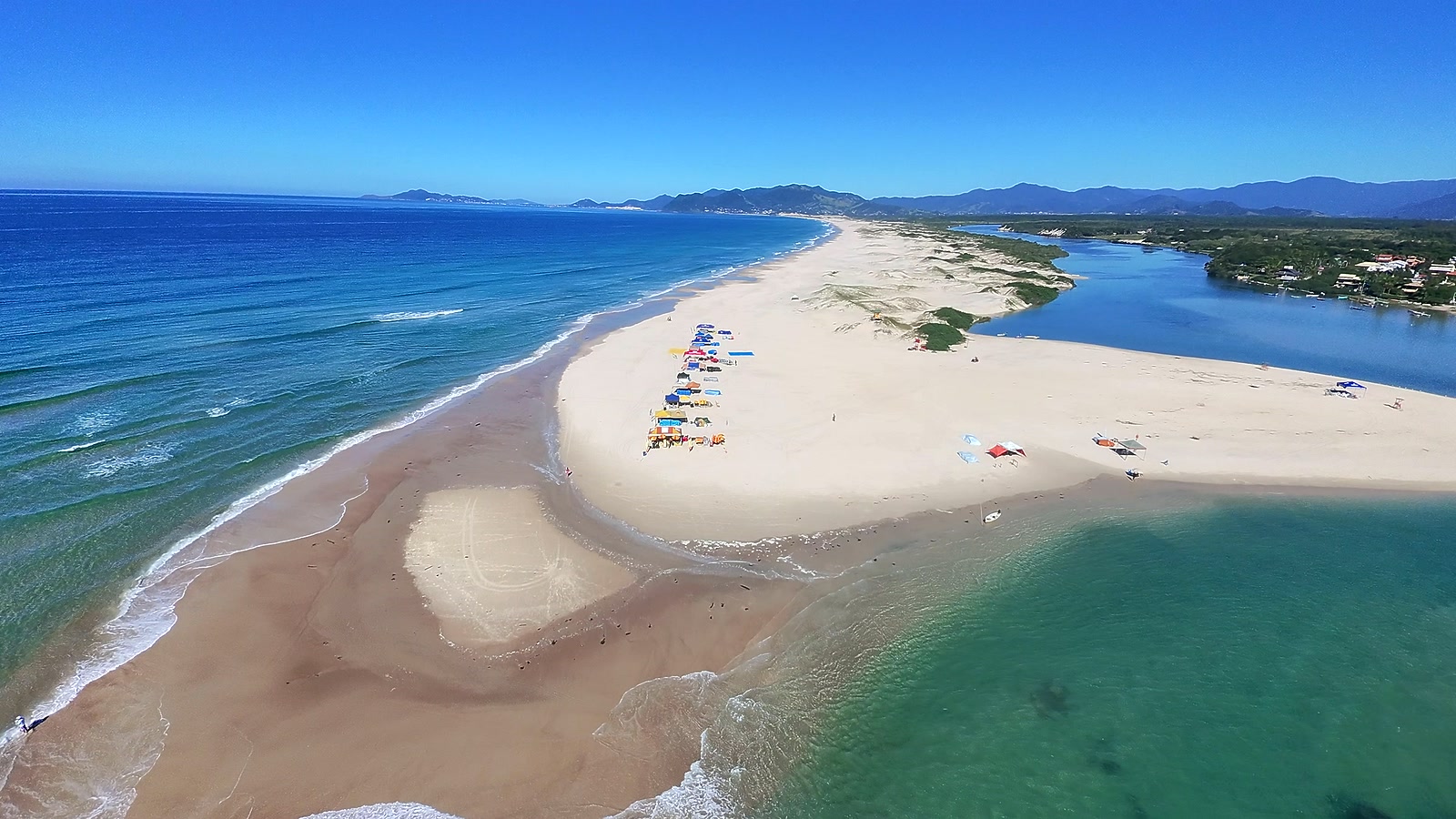 Vista aérea da Praia da Guarda do Embaú, com o encontro do rio com o mar perto da Pousada Capricórnio